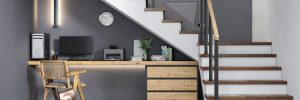 Office desk setup built underneath a staircase at the bottom of staircase landing