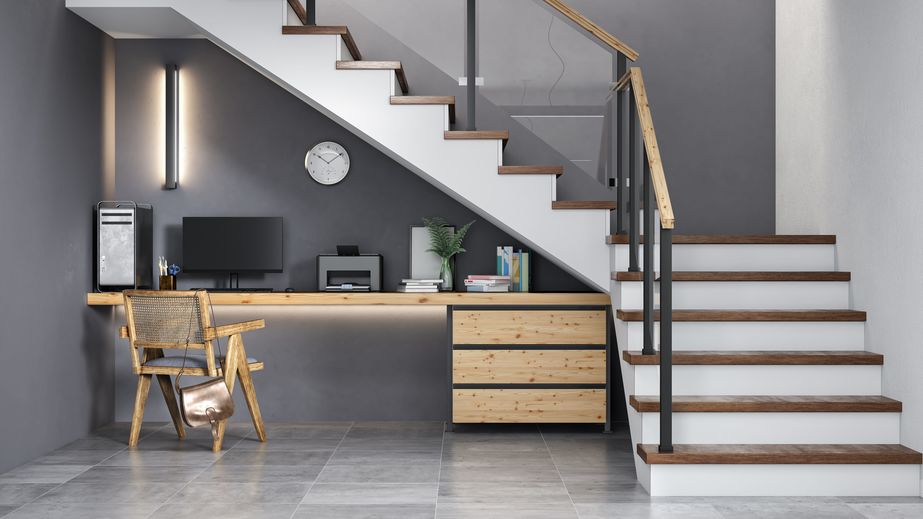 Office desk setup built underneath a staircase at the bottom of staircase landing