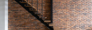 Modern stairs in room with brick wall