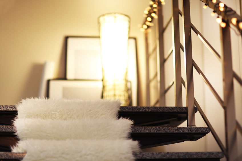 Modern stairs with electric garland, white furry bedspread and lamp